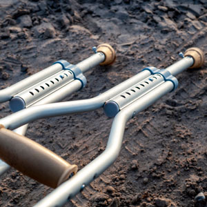 A pair of crutches lying on the ground, symbolizing a catastrophic injury - Law Offices of Daniel L. Clayton